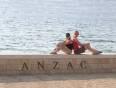Two girls sitting on a wall at ANZAC Cove, by the sea