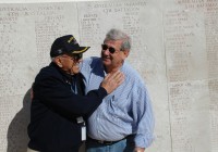 A guide and tour member at an ANZAC memorial