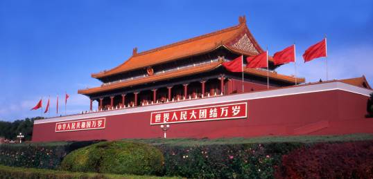 A man reading a newspaper outside the Forbidden City in Beijing