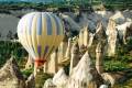 A hot air balloon gliding over the surreal landscape of Cappadocia