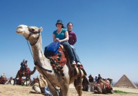Girls riding a camel at the pyramids on the Giza Plateau