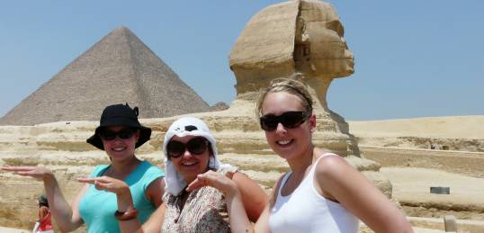 Girls striking an Egyptian pose in front of the Sphinx and pyramid on the Giza Plateau