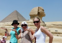 Girls striking an Egyptian pose in front of the Sphinx and pyramid on the Giza Plateau
