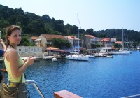 A girl viewing the boats in the port and the blue sea, from a boat