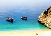 Two boats anchored where the Turquoise coast meets the sandy beach