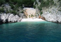 A tiny sandy bay set in glittering turquoise waters, reachable only by boat