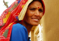 An Indian lady with a bright red headscarf