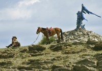 A Mongolian man on a hill with his horse