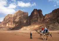 Local Bedouin tribesmen lead a camel safari through the desert sands of Wadi Rum in Jordan