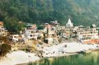 A view of Rishikesh and the Ganga river framed with lush vegetation