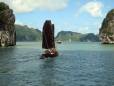 A junk sailing past a limestone peak in Halong Bay