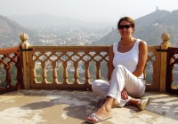 A lady sits by a magnificent view on a balcony at the City Palace in Jaipur