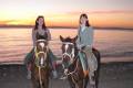 Two girls on a horse ride along the coast in Dahab at sunrise