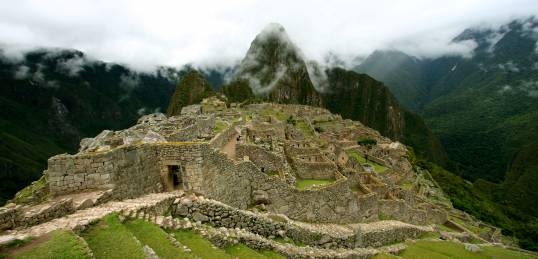 The early morning cloud dissipates to reveal stunning Machu Picchu on our Peru Tours 
