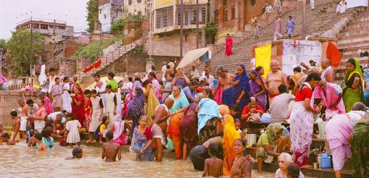 Colourfully dressed people bathing in the Ganges at Varanasi