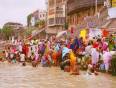 Colourfully dressed people bathing in the Ganges at Varanasi