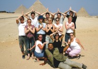 An on the go group striking a pose in front of the Pyramids of Giza