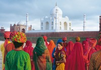 Brightly dressed Indian people gaze at the Taj Mahal