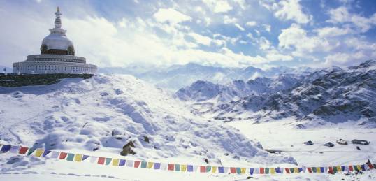 Shanti Stupa and snow covered mountains in Leh, Ladakh.