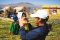 A girl holding a Peruvian baby on Taquille Island, Lake Titicaca