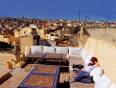 A lady relaxing in a rooftop garden, with views across Marrakech