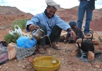 A Moroccan Berber pouring tea with his young son in the Altas Mountains