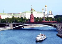 A ship sails under a bridge on the Moskva River in Moscow