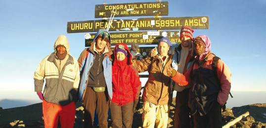 A happy group of trekkers, at the summit of Mt Kilimanjaro in Tanzania