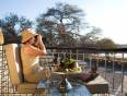 A lady wildlife spotting from a lodge in Etosha