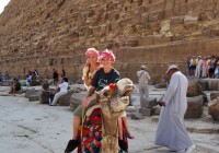 A couple riding a camel at the Pyramids of Giza