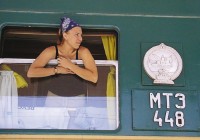 A girl leaning out the window of a Tranas-Siberian train