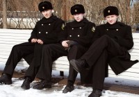 Three Russian officials clad in black with black furry hats