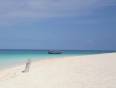 White sands and crystal clear waters of the beaches of Zanzibar with a traditional dhow