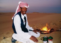 Egypt Tours - An Egyptian man preparing tea, on the rolling dunes of the Great Sand Sea