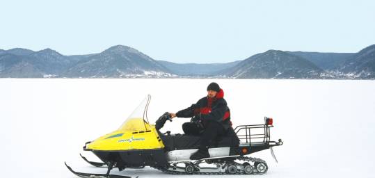 Man riding a snow mobile on the frozen expanse of Lake Baikal