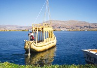 A man sailing a boat made of Totara reed on Lake Titicaca in Peru