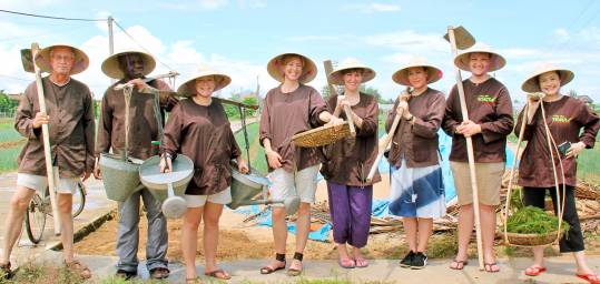 A group learning old farming practises in Tra Que on a Vietnam group tour