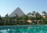 View of the Mena House Hotel with the Pyramids of Giza in the distance