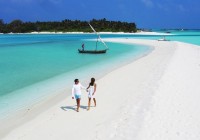 A couple enjoying the beautiful white sand beaches and crystalline azure waters of the Maldives