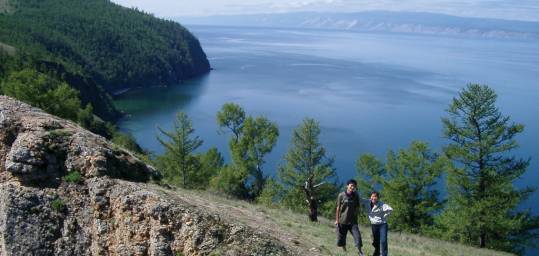 Two people trekking along the shores of Lake Baikal in Siberia