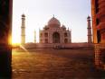 The Taj Mahal at sunrise viewed through wooden gates