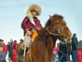 A Mongolian boy sits atop a furry horse