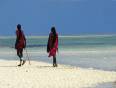 Two members of the Masai  tribe walking along a beautiful beach in Zanzibar