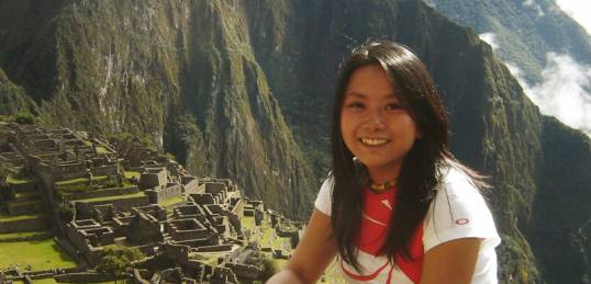 A girl at the Sun Gate looking down on Machu Picchu
