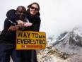 A couple cuddling by the Everest Base Camp sign