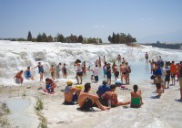 People relaxing in the sun at the white limestone terraces of Pammukale