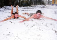 A couple brave the cold and lie in the snow after a steamy Russian sauna