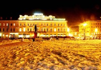 The bright lights of the city reflect against the snow