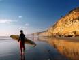 A man by the sea in Morocco with a surf board