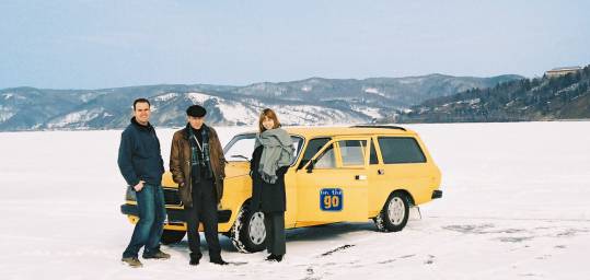 Three people and their car on the frozen expanse of ice on Lake Baikal